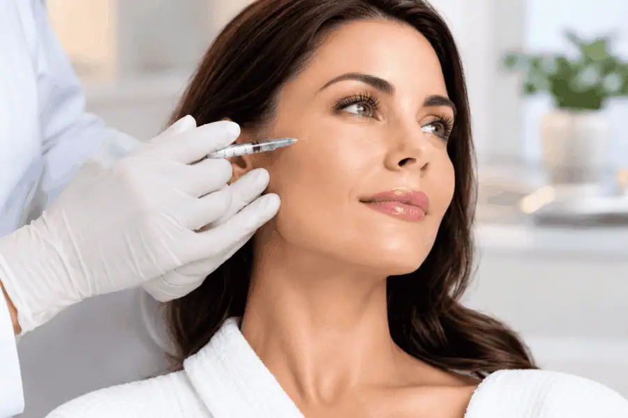 A patient receiving a professional Sculptra facial injection treatment from a practitioner at Bradenton Aesthetics in Bradenton, Florida.